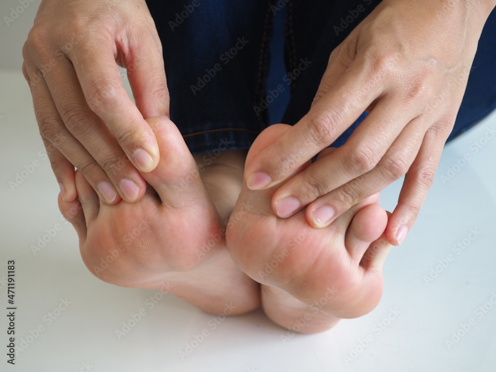 Foot pain woman hand holding a sore foot on white background. closeup photo, blurred. Foot pain woman hand holding a sore foot on white background. closeup photo, blurred.