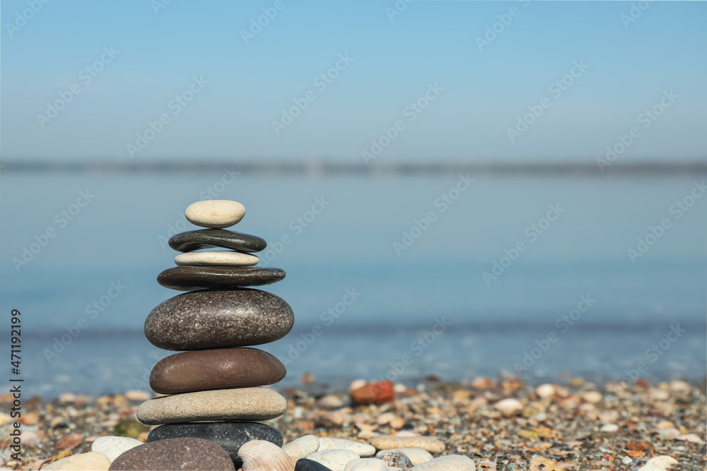 Fototapeta premium Stack of stones on beach, space for text. Harmony and balance concept