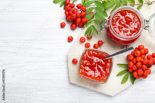 Flat lay composition with delicious rowan jam on white wooden table. Space for text photo