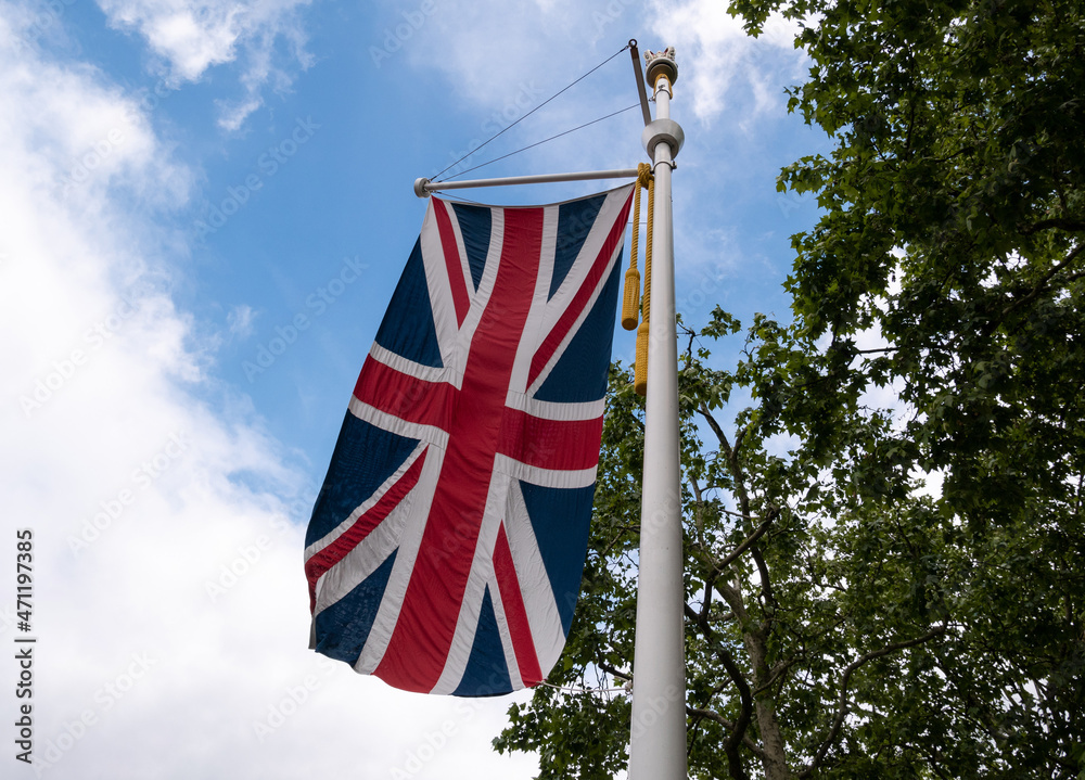 National flag of the United Kingdom (Union Jack) fluttering on a pole in London, England.