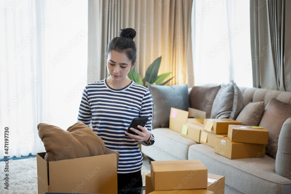 Small business owner confirming orders from customer on mobile phone while working at home. Small business owner confirming orders from customer on mobile phone while working at home.