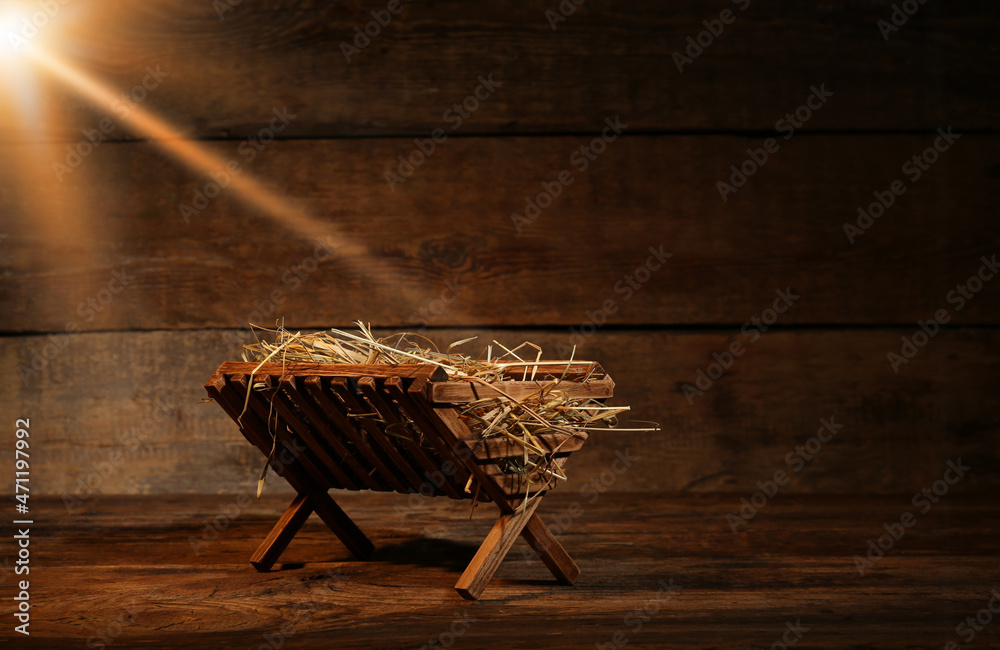 Manger with hay on wooden background. Concept of Christmas story