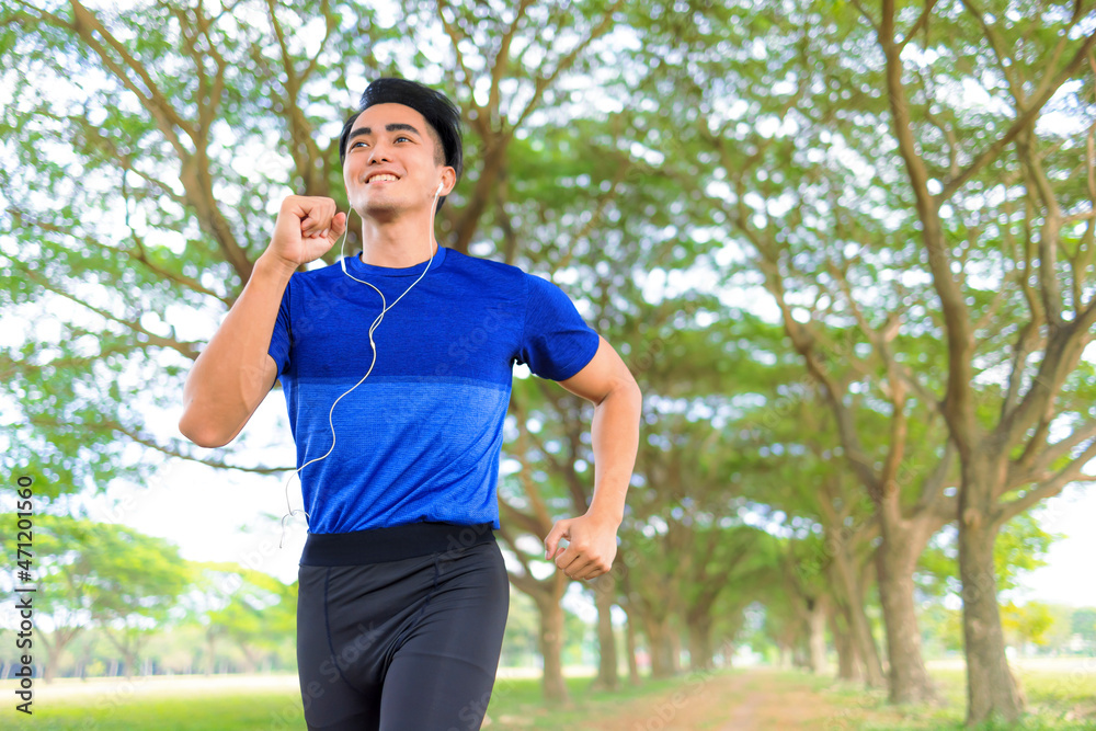 Happy Young man jogging in the city park