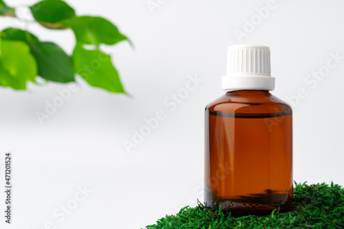 Fototapeta Naklejka Na Ścianę i Meble -  Cosmetics in a bottle, essential oil on moss