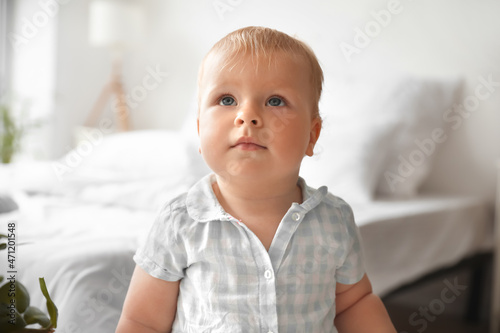 Adorable baby girl in bedro...