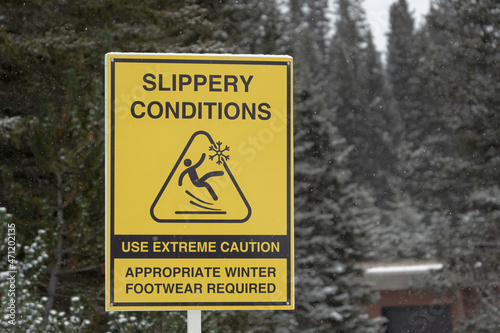 Slippery conditions warning sign in national park during snowfall