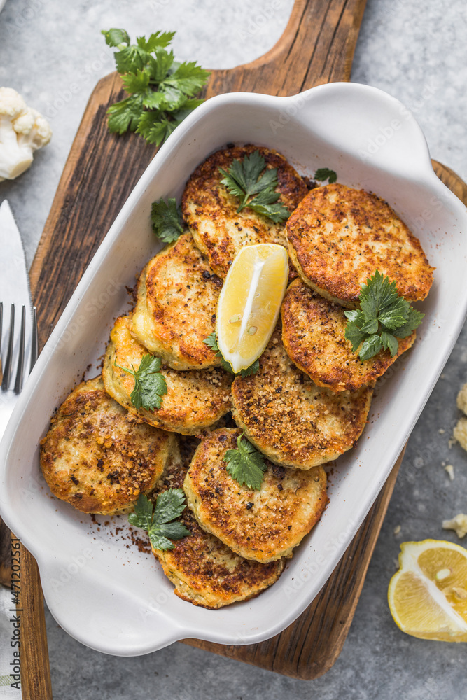 Vegan cauliflower vegetable fritters on the kitchen table. Fried vegetarian cutlets or pancakes. The concept of fast food.