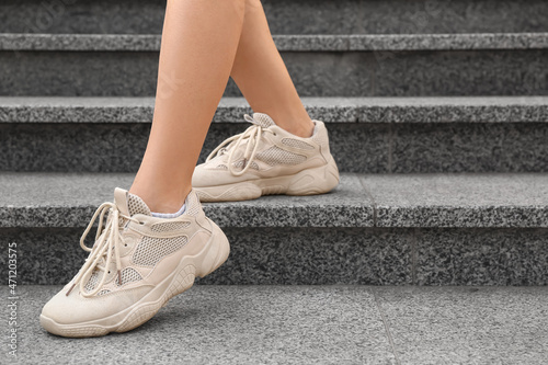 Legs of woman in white sneakers on stairs outdoors, closeup © Pixel-Shot