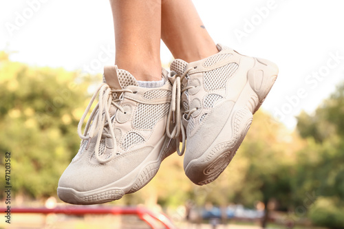 Woman in white sneakers on sport ground  closeup