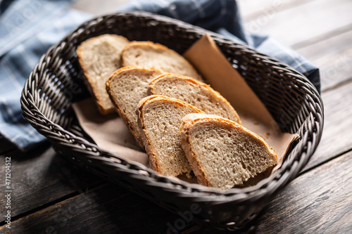 Bild auf Leinwand Slices of bread served in a basket in a rustic environment