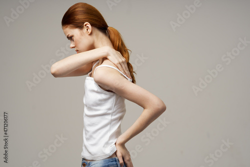 woman in white t-shirt pain in the neck arthritis chronic disease studio treatment