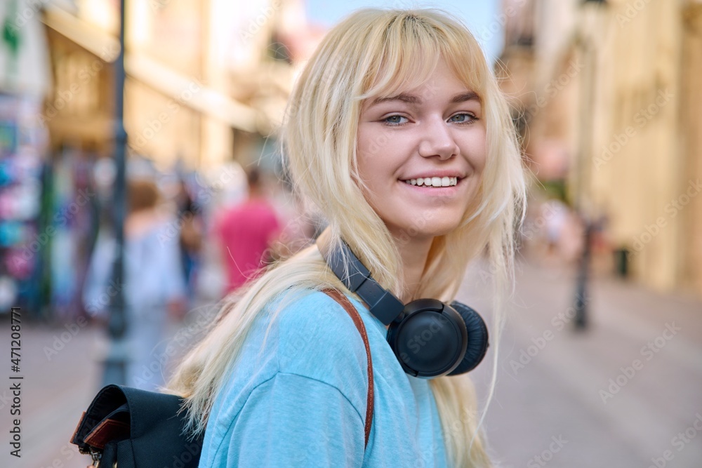 Fototapeta premium Outdoor portrait of a happy smiling teenage girl 17 years old
