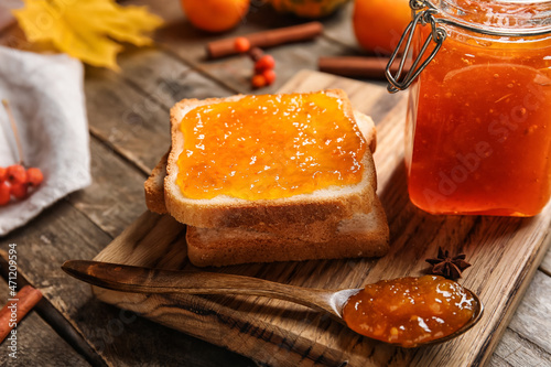 Toasts with sweet pumpkin jam on wooden background photo