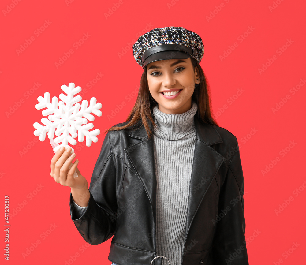 Beautiful woman in cap with big snowflake on red background Beautiful woman in cap with big snowflake on red background