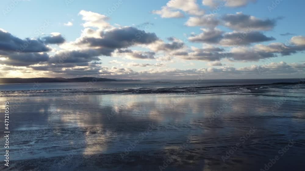 A slow push in across the beautiful reflective beach, with the clouds shimmering back. A slow push in across the beautiful reflective beach, with the clouds shimmering back.