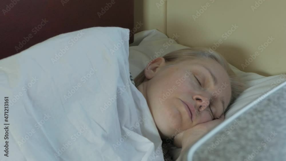 A tired woman sleeps lying in a compartment during a train ride A tired woman sleeps lying in a compartment during a train ride