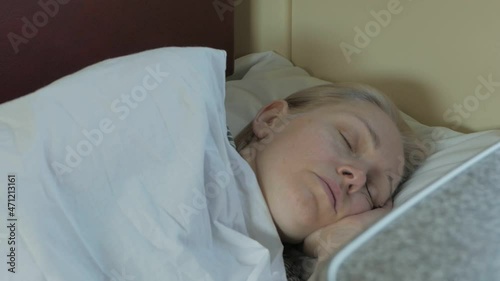 A tired woman sleeps lying in a compartment during a train ride
