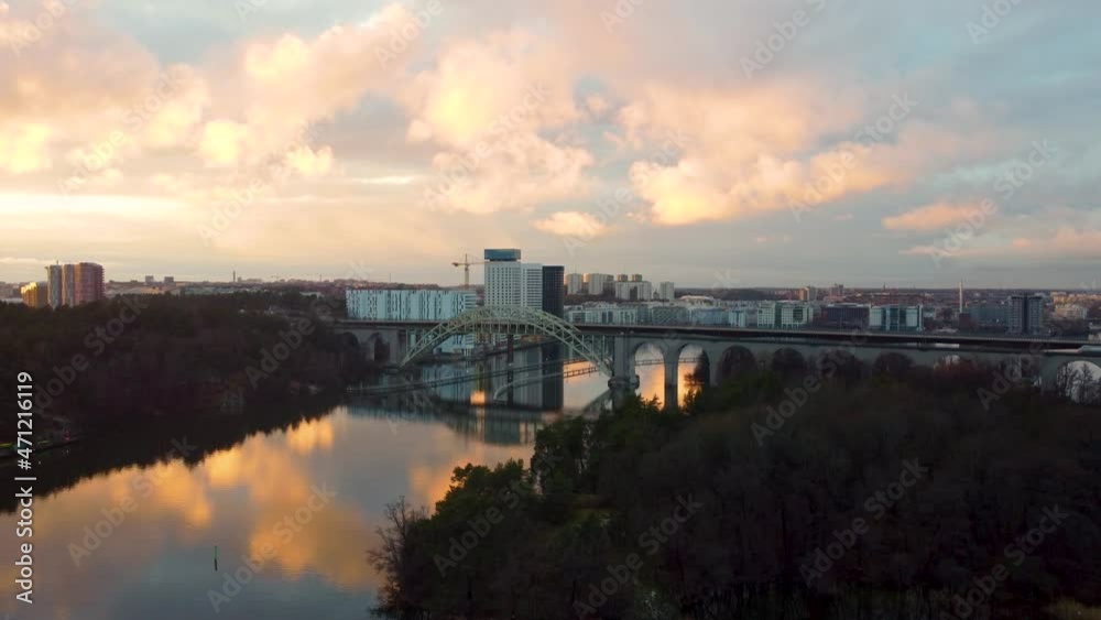 Forward aerial of bridge and still water at cloudy sunset in Stockholm Forward aerial of bridge and still water at cloudy sunset in Stockholm
