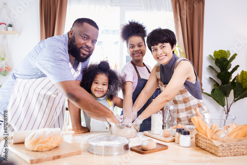 African American family help prepare the flour for making cookies. Happy African American family