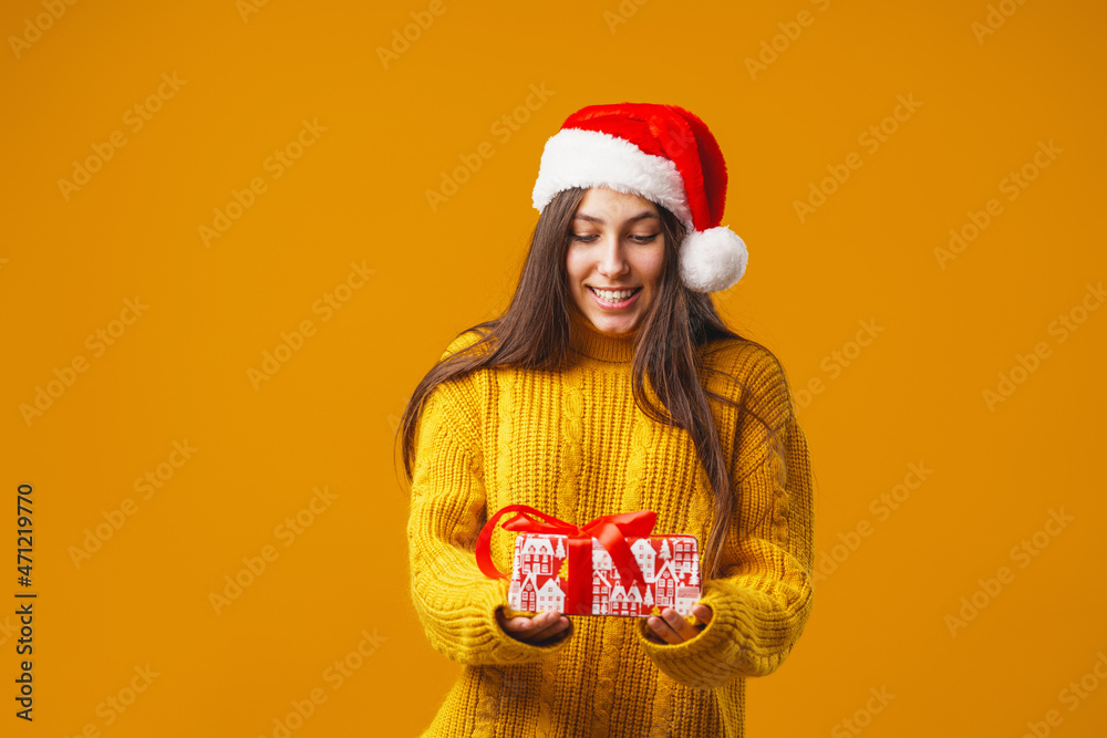 surprise cute girl 15 years old with, standing with gift boxes on a yellow background in studio. female smiles happily and looks into the frame. Advertising. copy space surprise cute girl 15 years old with, standing with gift boxes on a yellow background in studio. female smiles happily and looks into the frame. Advertising. copy space