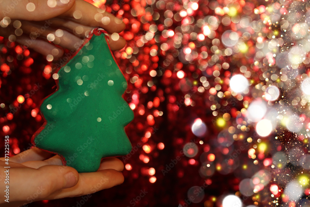 beautiful green Christmas tree is lying on your hand on a shiny background