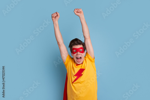 Excited superhero man flying in studio