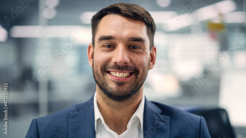 Portrait of a Confident Happy Businessman Wearing a Casual Suit, Looking at Camera, Genuinely and Charmingly Smiling. Successful Experienced Man Working in Diverse Company Office. photo