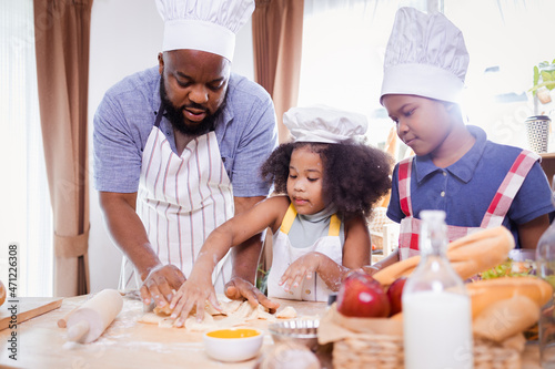 African American family help prepare the flour for making cookies. Happy African American family