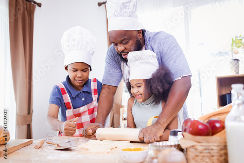 African American family help prepare the flour for making cookies. Happy African American family