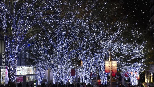 TOKYO, JAPAN - NOV 2021 : Christmas illumination, led light up and snow at Roppongi Keyaki-zaka (Keyaki hill). Scenery of downtown city and street at night. Winter and Christmas season concept. photo