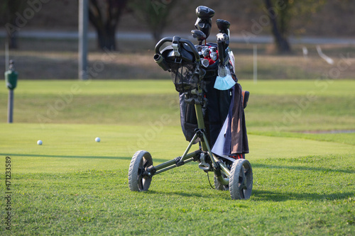 Black Golf Trolley Bag With Wheels in golf course in sunny day