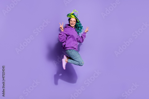 Full length photo of cheerful lady with shine haircut jump make v-sign isolated over purple color background © deagreez