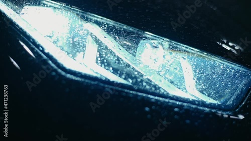 Close-up of headlights burning at night. Burning car headlight. photo