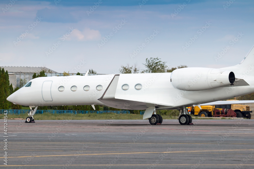Close-up of modern white corporate business jet at the airport apron
