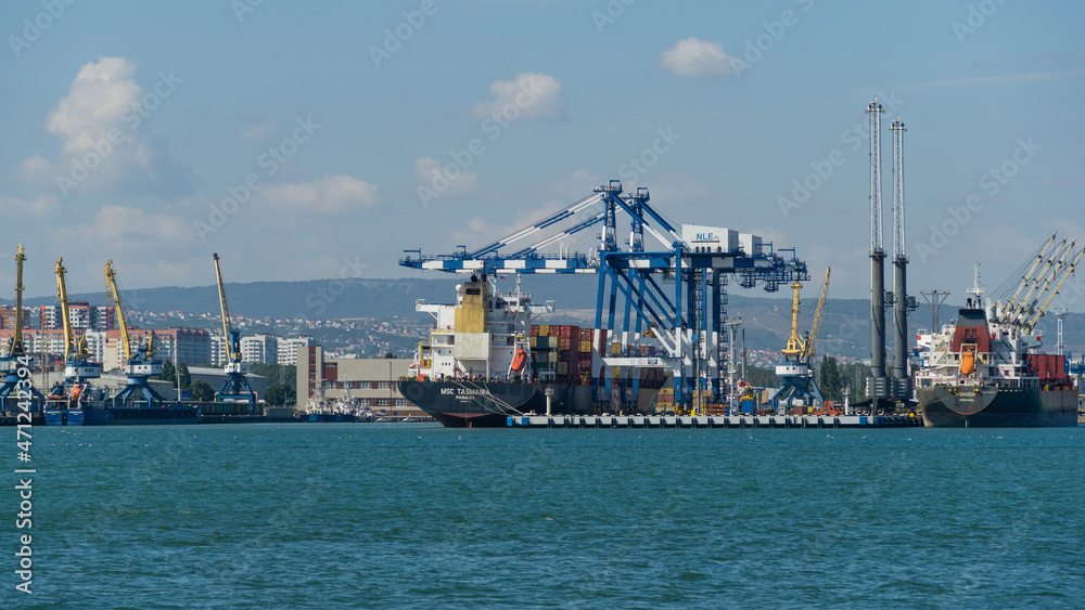 View of Novorossiysk Commercial Sea Port to container ship MSC Tasmania Panama, Port cranes. Largest Russian port in Tsemes bay of the Black Sea. Novorossiysk, Russia - September 15, 2021