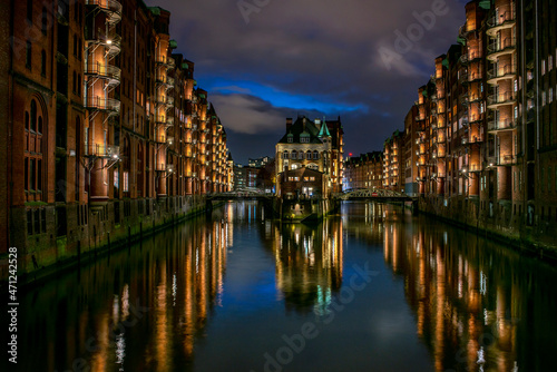 Detailliertes Panoramafoto der beleuchteten Speicherstadt in Hamburg mit Reflexionen der Lichter im Wasser (November 2021) © yourpix
