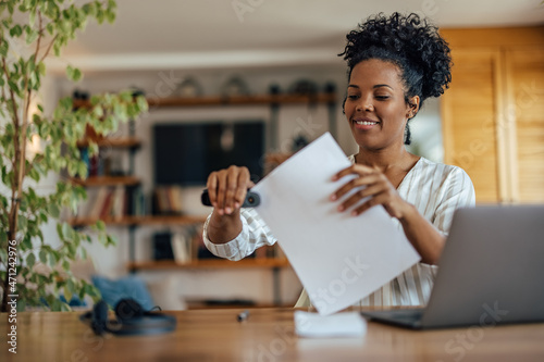 Fotografía Happy african-american woman, using office appliances