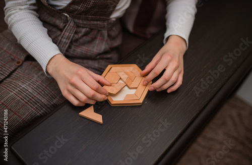the girl's hand folds wooden blocks. Problem solving concept and plan for success. Top view of wooden blocks. The concept of the decision-making process, logical thinking. Logical tasks. puzzle