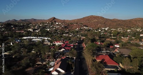 4K aerial Windhoek capital residential central hilly district bright sunset drone video, blooming Jacaranda trees, upmarket houses, old white walls German mansions in Khomas Region, central Namibia photo