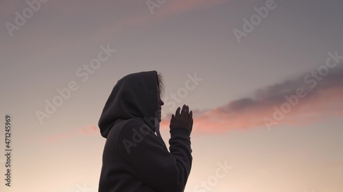 Girl praying on a pink sky background, believe in good good, ask for help, dream looking up, motivation inspiration outdoors, woman thinks meditating, wanderlust concept, heavenly light