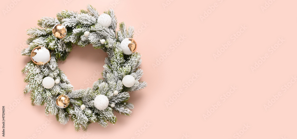 Christmas wreath of snowy branches with white and gold baubles on pink background. New Year greeting card. Top view. Traditional decoration for Xmas holiday in luxury modern style with gold potal.