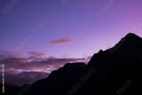 Crescent moon over mountain at dusk
