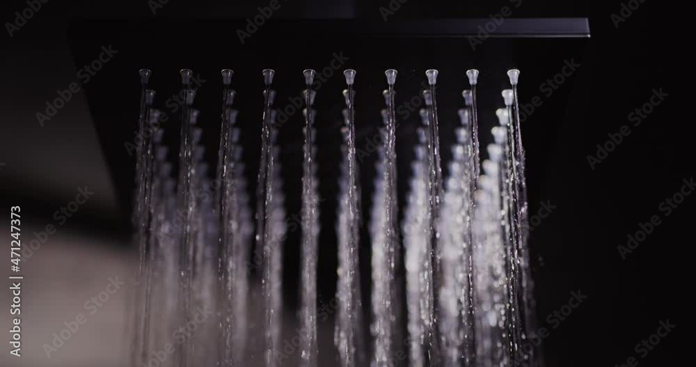 Water flows from a black square nozzle in the shower. 4k slow motion video