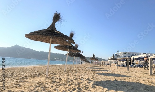 Empty Moroccan sandy beach with straw umbrellas