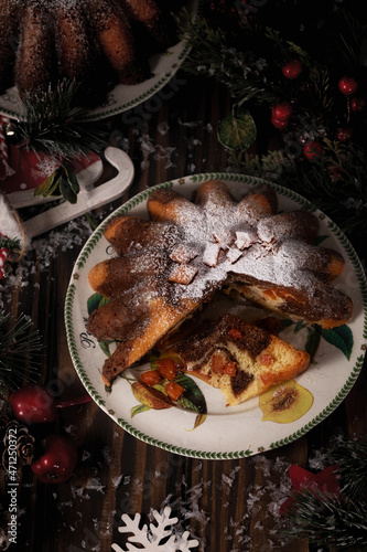 Traditional homemade chocolate christmas cake with orange candied fruits powdering with icing sugar