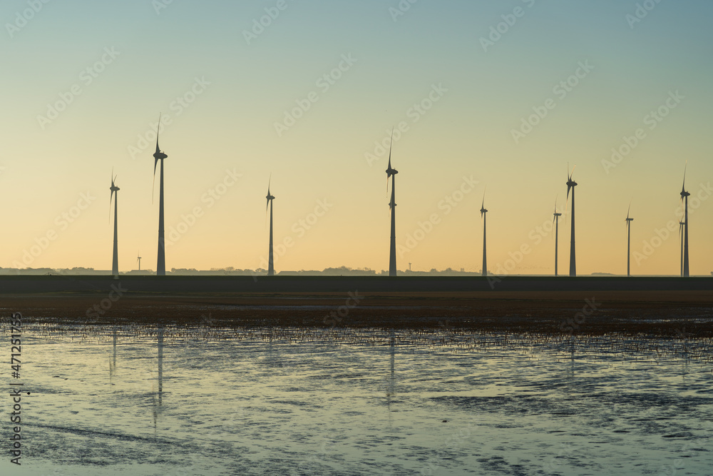 Wind turbines spinning at the Dutch coast on a sunny afternoon. Wind turbines spinning at the Dutch coast on a sunny afternoon.