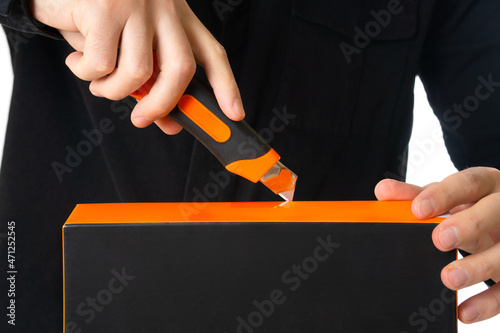 Man using a cutter to open a box