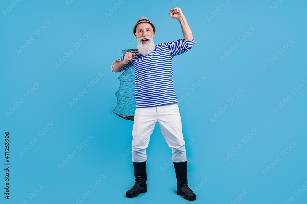 Full body photo of charming happy positive man winner hold hand fishnet isolated on pastel blue color background Full body photo of charming happy positive man winner hold hand fishnet isolated on pastel blue color background