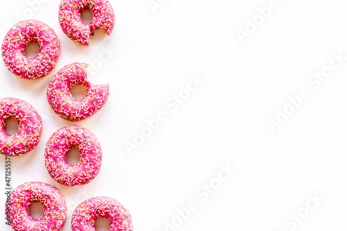 Pink donuts with sprinkles set, top view. Sweet bakery background