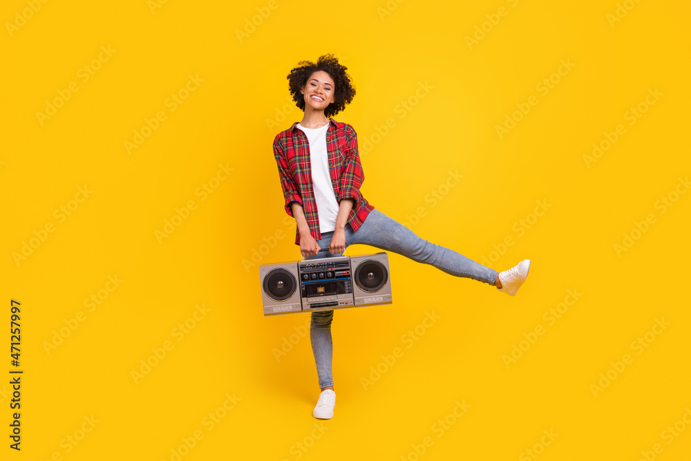 Fototapeta premium Full length body size view of attractive carefree cheerful girl dancing holding player isolated over bright yellow color background